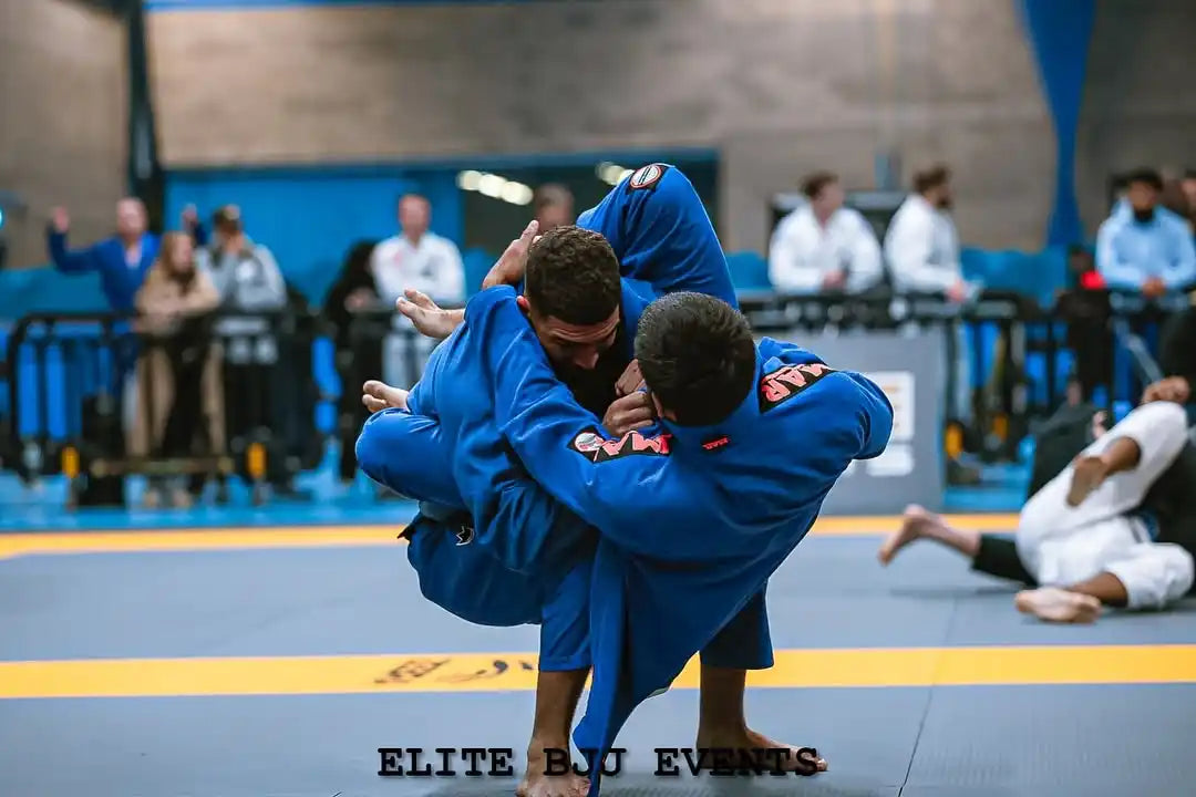 Two men grappling in blue uniforms.