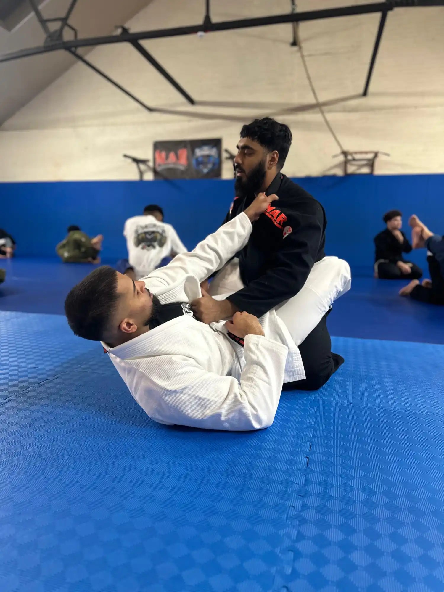 Two men grappling in martial arts uniforms.